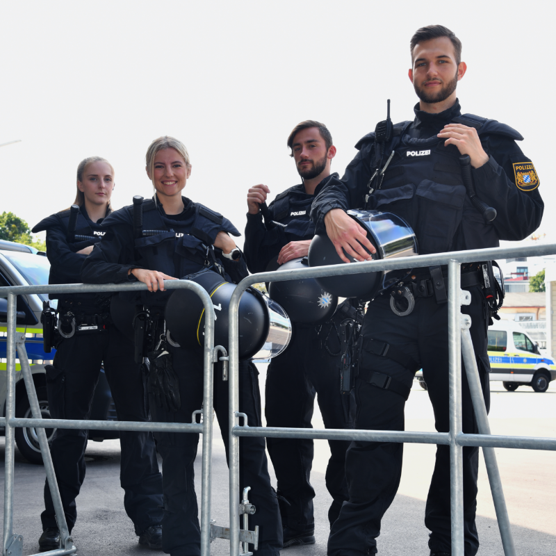 Team der Bayerischen Polizei mit vier Kolleginnen und Kollegen in ihrer Uniform und mit Ausrüstung.
