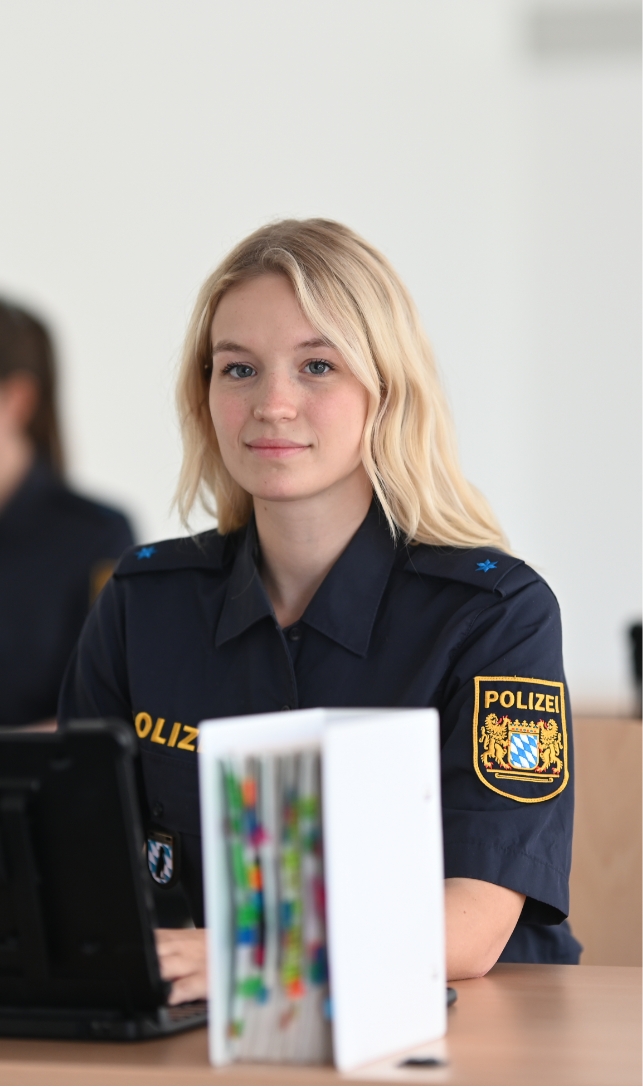 Auszubildende der Bayerischen Polizei im Unterricht mit einem Convertible und einem Gesetzbuch.