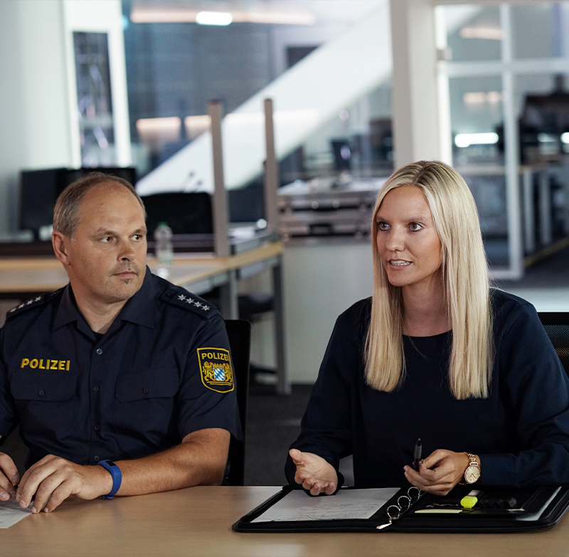 IT-Kriminalistin der Bayerischen Polizei in der Diskussion mit ihrem Team.