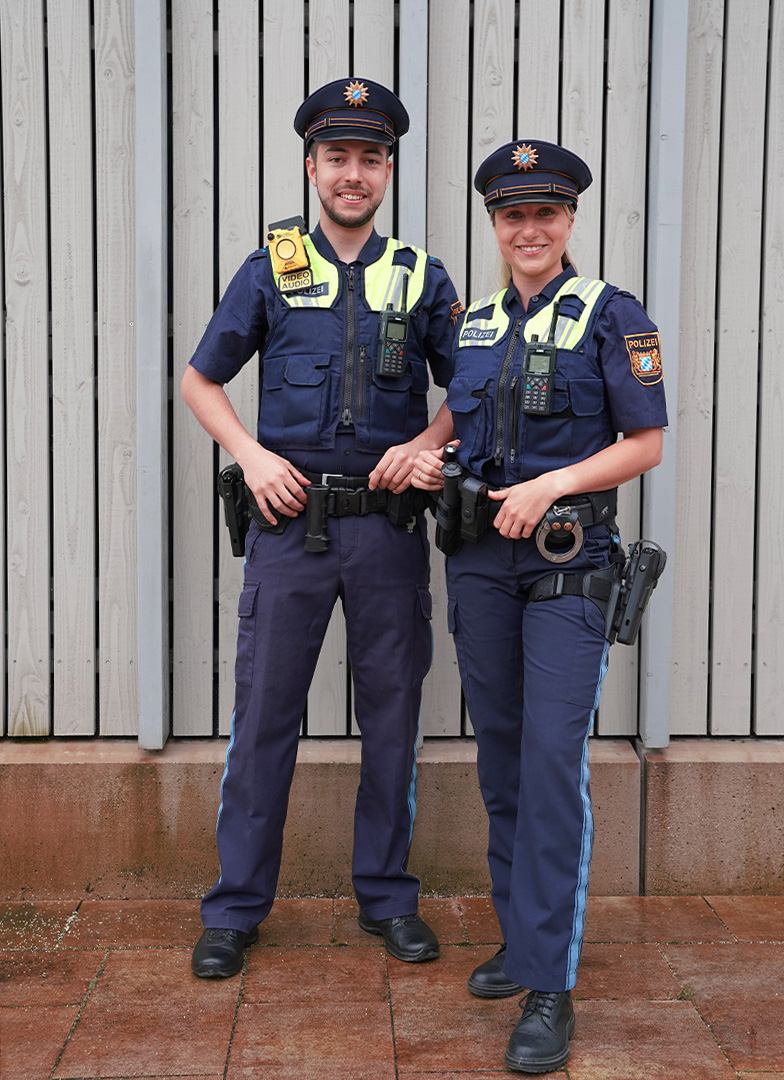 Eine Kollegin und ein Kollege der Bayerischen Polizei in ihrer Dienstkleidung.