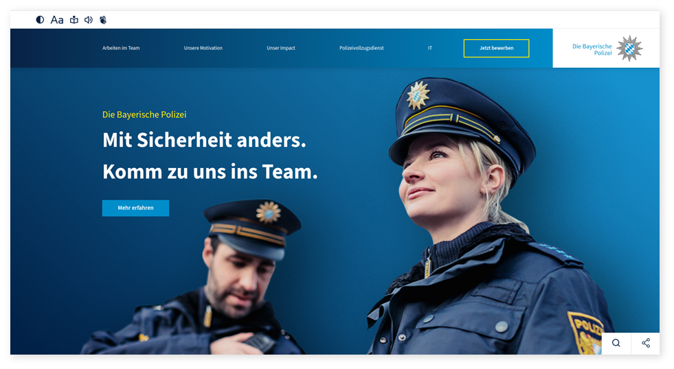 Bild von der Internet-Seite. 
Darauf ist eine Polizistin und ein Polizisten in blauer Dienst-Kleidung zu sehen. 
Daneben steht in weißer Schrift: "Die Bayerische Polizei. Mit Sicherheit anders. Komm zu uns ins Team."